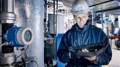 Temperature transmitter iTEMP TMT142B next to an Endress+Hauser employee in the field