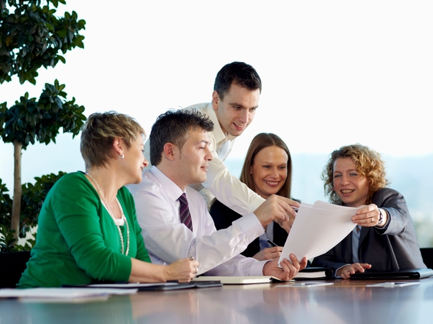 Discussie van een groep medewerkers aan een grote vergadertafel.