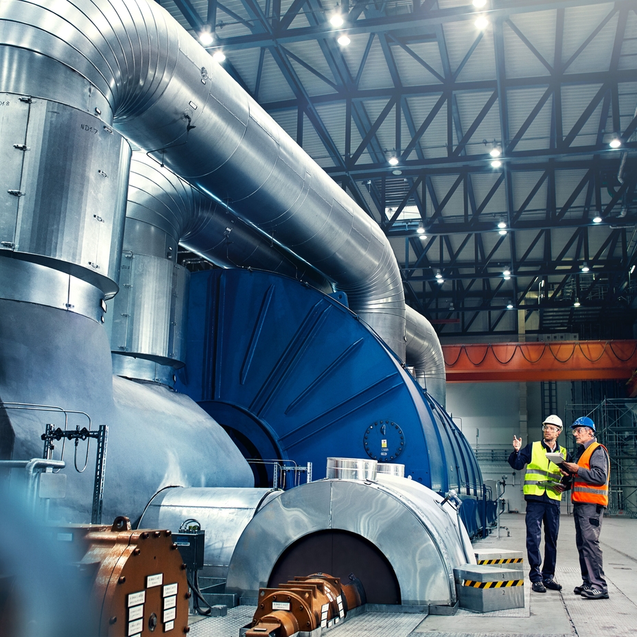 Close-up picture of an engineer in front of a turbine in a power plant