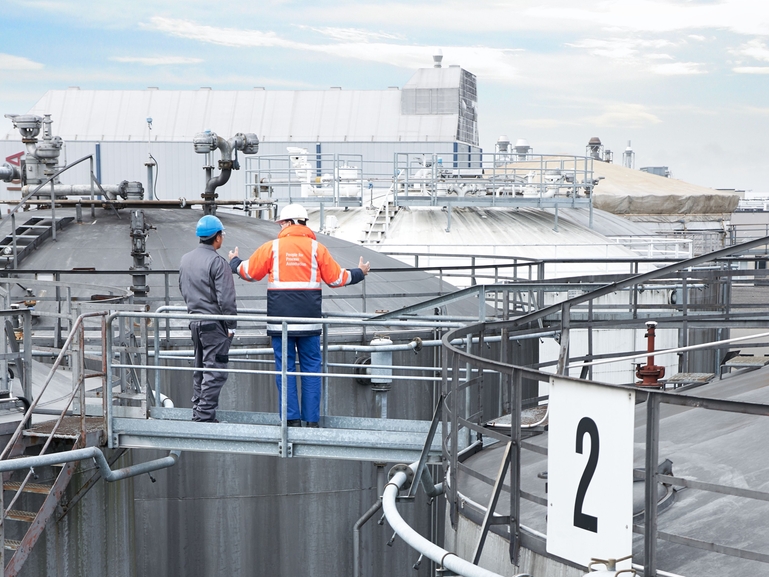 Voorkom het overlopen van tanks in de olie- en gasindustrie. Afbeelding van tankpark/olietanks in een raffinaderij. Endress+Hauser samen met klant.