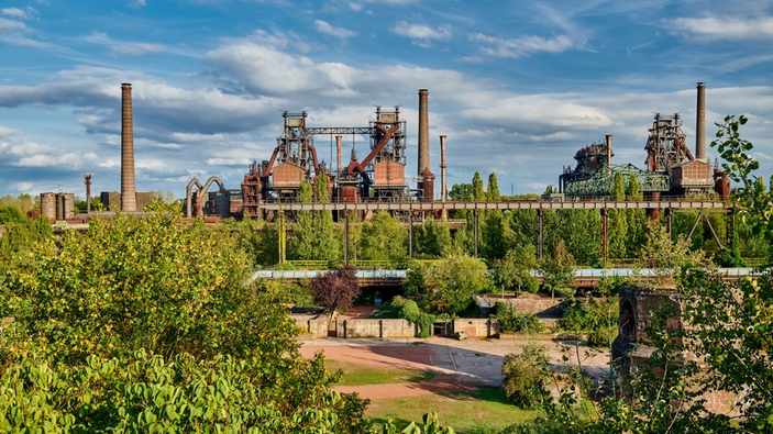 Staalfabriek midden in een groen landschap.