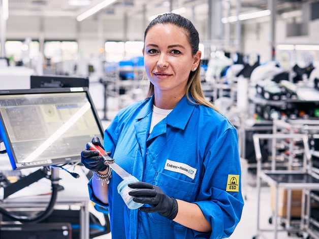 Productiemedewerker staande bij een assemblagestation.