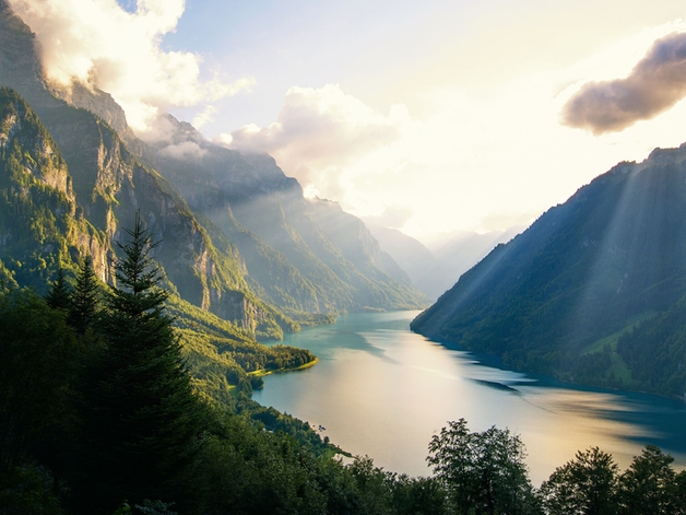 Meer omringd door beboste bergen.