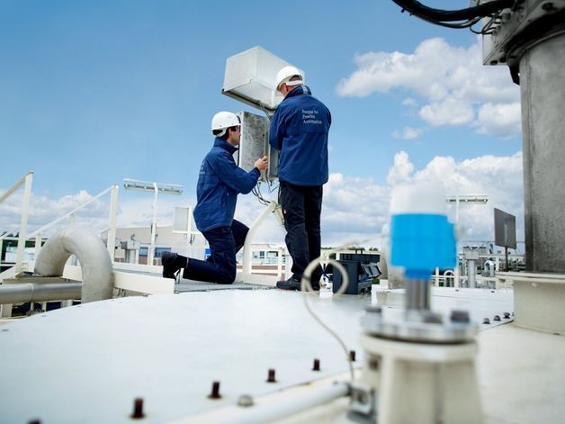 Twee servicespecialisten aan het werk in een industriële omgeving.